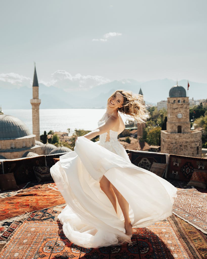 A bride dances energetically on a rooftop with historical architecture behind her.